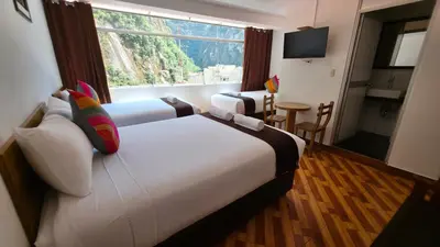 a hotel room with a large bed and a window at Mapi Garden's Machupicchu in Machu Picchu