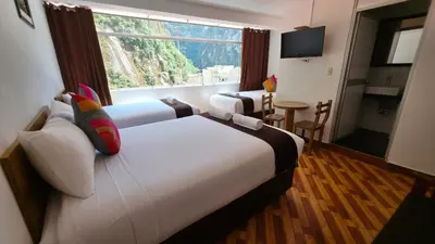 a hotel room with a large bed and a window at Mapi Garden's Machupicchu in Machu Picchu