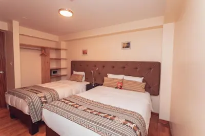 two beds in a room with two beds sidx sidx sidx at Hotel Las Quenas in Cusco