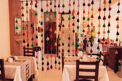 a dining room with two tables and a wall of decorations at Hotel Las Quenas in Cusco