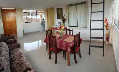 a dining room with a table and chairs and a couch at Feliz Vista Casa-Hospedaje in Cusco