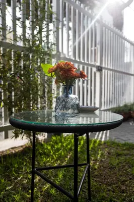 a glass table with a vase with flowers on it at Belma Boutique Bed and Breakfast in Lima