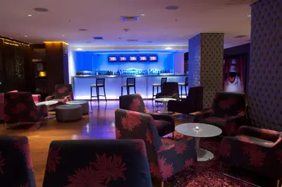 a lobby with chairs and a bar in the background at Radisson Hotel Decapolis Miraflores in Lima