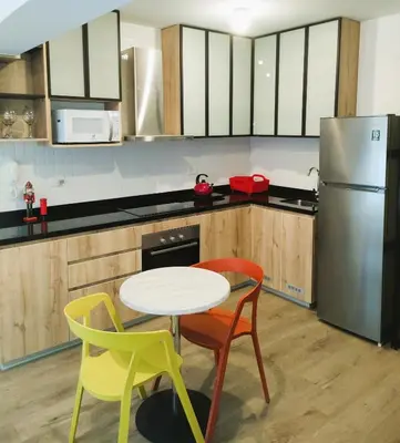 a kitchen with a table and two chairs and a refrigerator at LA POSADA DE GUILLE LUXURY 1 HABITACION - Surco in Lima