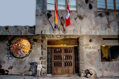 a building with two flags on the side of it at Hotel Warari in Cusco