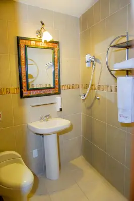 a bathroom with a sink and a toilet and a mirror at Hotel Warari in Cusco