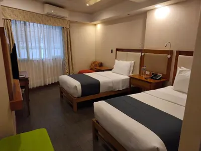 a hotel room with two beds and a window at La Luna Inn in Lima
