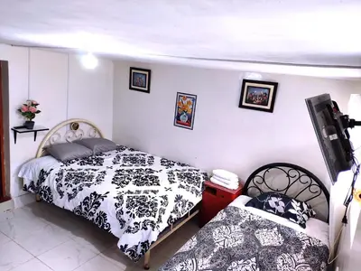 a bedroom with two beds with black and white sheets at Cuzco Central Hostel in Cusco
