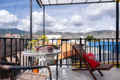 a balcony with a table and chairs and a view of the ocean at Casa Samaykuy in Ayacucho