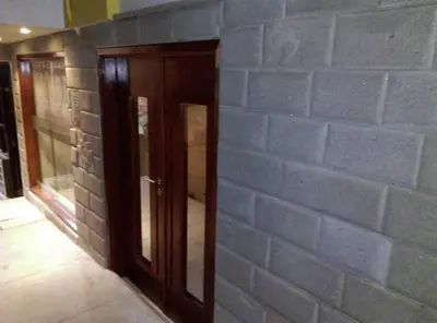 a room with a brick wall and a wooden door at Picos House MachuPicchu in Machu Picchu
