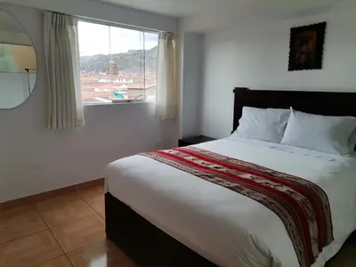 a bedroom with a large bed with a window at Apartment Samana House in Cusco