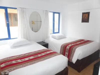 a hotel room with two beds and a mirror at Apartment Samana House in Cusco