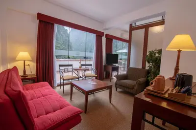a living room with a red couch and a table at Tierra Viva Machu Picchu Hotel in Machu Picchu