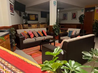 a living room with couches and tables and plants at Hotel Chinchero Boutique & Tours in Chinchero
