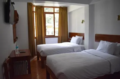 a hotel room with two beds and a window at Casa De Luz Hotel in Machu Picchu