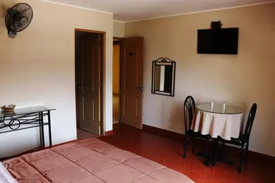 a room with a table and a chair and a room with a door at Hotel Bohemia in Lima