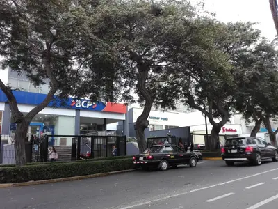 two cars parked in front of a store with trees at Los Q'eros in Lima