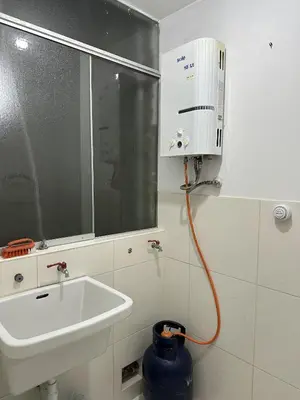 a bathroom with a sink and a water hose at VIVE Apartments Cusco in Cusco