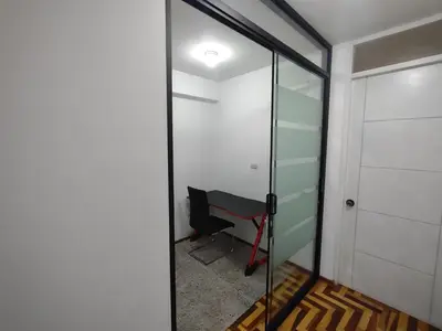 a glass door leading into a room with a desk at VIVE Apartments Cusco in Cusco