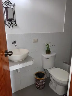 a white bathroom with a sink and a toilet at Suzet House in Oxapampa
