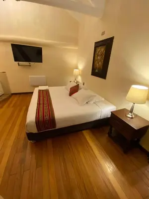 a bedroom with a bed and a tv on the wall at Cusco Hotel Boutique in Cusco