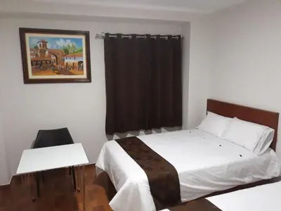 a bedroom with a bed and a table and a picture at Gran Caral Hotel in Barranca