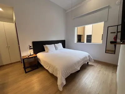 a bedroom with a white bed and a window at Sori Apartments in Lima