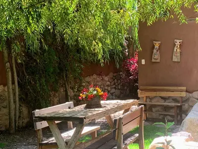 a wooden table with a vase of flowers on it at Bungalows Perayoc in Urubamba