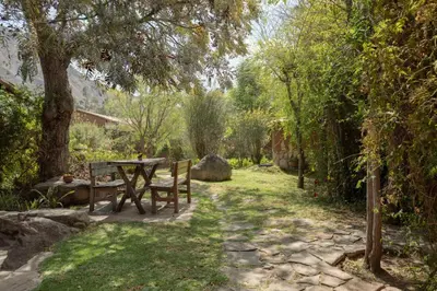 a picnic table and bench in a garden at Bungalows Perayoc in Urubamba