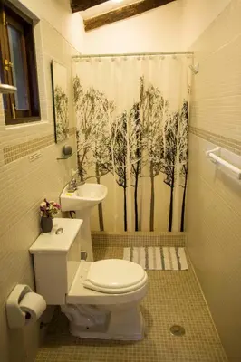 a bathroom with a toilet and a shower curtain at Bungalows Perayoc in Urubamba