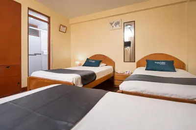 a hotel room with two beds and a window at Ayenda Posada Inn in Cusco