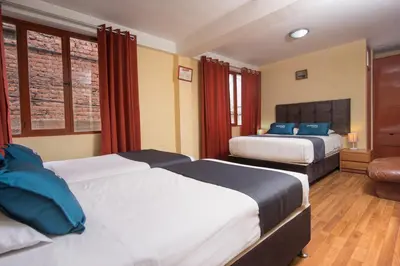 a hotel room with two beds with blue pillows at Ayenda Posada Inn in Cusco