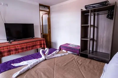 a bedroom with a bed with towels on it at Askha Cusco in Cusco