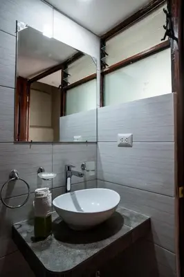 a bathroom with a sink and a mirror at Askha Cusco in Cusco