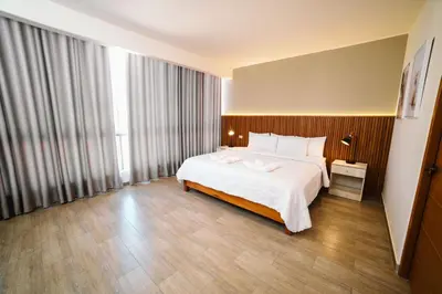 a bedroom with a large bed and a large window at Villa Oasis in Ica