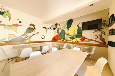 a dining room with a mural of birds on the wall at Villa Oasis in Ica