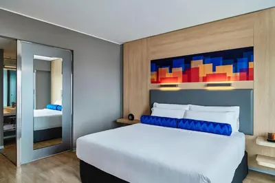a bedroom with a large white bed and a mirror at Aloft Lima Miraflores in Lima