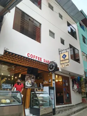 a man standing in front of a coffee shop at Viandina Machupicchu in Machu Picchu