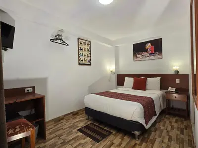 a hotel room with a bed and a desk at Viandina Machupicchu in Machu Picchu