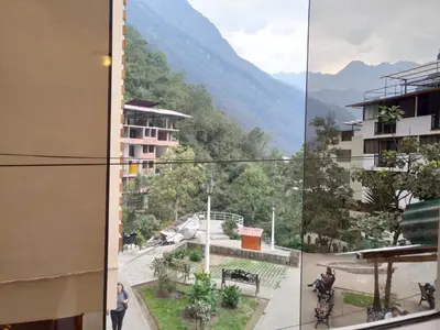 a woman standing outside of a building looking out at the mountains at Viandina Machupicchu in Machu Picchu