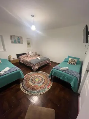 a room with two beds and a rug at Uli´s house in Lima