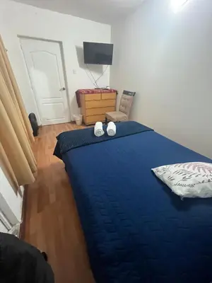a bedroom with a blue bed with two white shoes on it at Uli´s house in Lima
