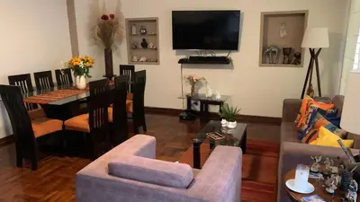 a living room with a couch and a dining room at Uli´s house in Lima
