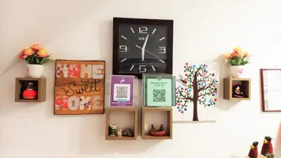 a wall with a clock and some pictures on it at Anccalla Inn Guesthouse in Nazca