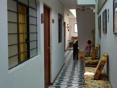 a hallway with two chairs and a girl in a room at Anccalla Inn Guesthouse in Nazca