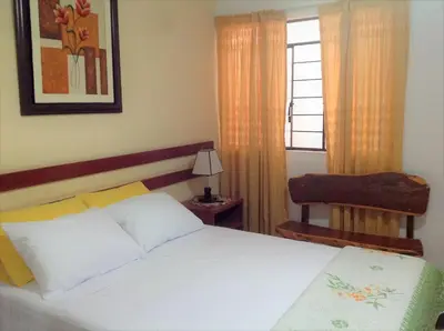a bedroom with a white bed and a window at Anccalla Inn Guesthouse in Nazca