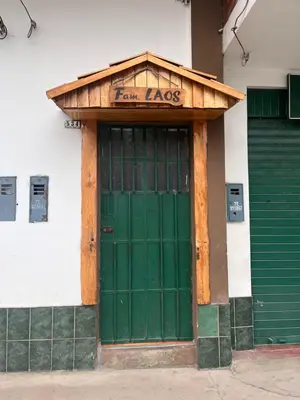 a green door on the side of a building at Hospedaje Familiar Laos in Oxapampa