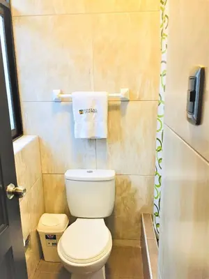 a small bathroom with a toilet and a towel at Hostal Carlos Tenaud in Lima