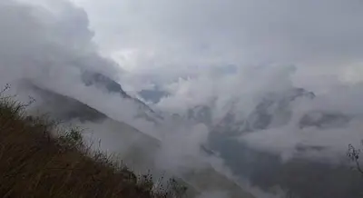 a view of a mountain with clouds in the sky at Eco Hacienda Roman in Machu Picchu