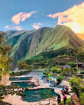 a group of people in a river with a mountain at Eco Hacienda Roman in Machu Picchu